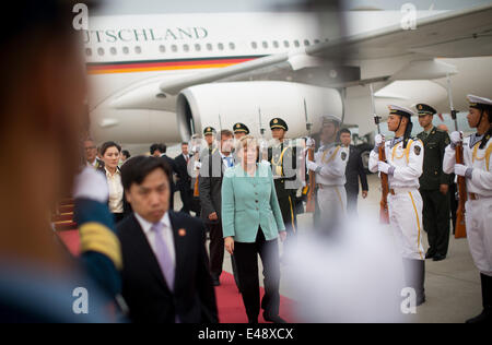 Beijing, Chine. 6 juillet, 2014. La chancelière allemande Angela Merkel (C), arrive à l'aéroport de Beijing, Chine, 6 juillet 2014. Angela Merkel est accompagné d'une délégation de haut niveau de l'Allemagne et va rester en Chine avant le 08 juillet 2014. Photo : Kay Nietfeld/dpa/Alamy Live News Banque D'Images