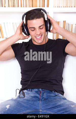 Smiling man wearing headphones et walking Banque D'Images