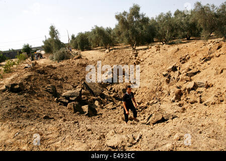 Khan Yunis, la bande de Gaza, en Palestine. Le 06 juillet, 2014. Les Palestiniens d'une inspection du site d'une frappe aérienne israélienne à Khan Younis dans le sud de la bande de Gaza le 6 juillet 2014. Des avions israéliens ont attaqué 10 sites utilisés par les militants palestiniens dans la bande de Gaza le dimanche en réponse à la persistance des frappes de fusée à partir de l'enclave, les militaires israéliens ont dit. Credit : Abed Rahim Khatib /Pacific Press/Alamy Live News Banque D'Images