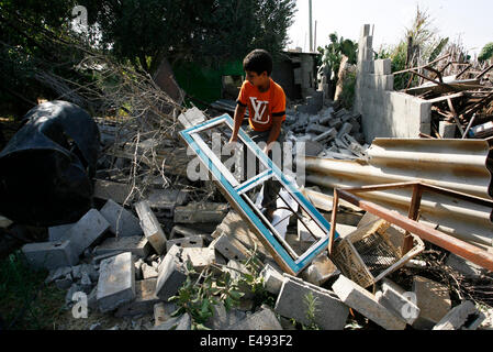 Rafah, bande de Gaza, en Palestine. Le 06 juillet, 2014. Un homme palestiniens inspecte les débris d'un bâtiment détruit à la suite d'une frappe aérienne israélienne à Rafah, au sud de la bande de Gaza le 6 juillet 2014. Des avions israéliens ont attaqué 10 sites utilisés par les militants palestiniens dans la bande de Gaza le dimanche en réponse à la persistance des frappes de fusée à partir de l'enclave, les militaires israéliens ont dit. Credit : Abed Rahim Khatib /Pacific Press/Alamy Live News Banque D'Images