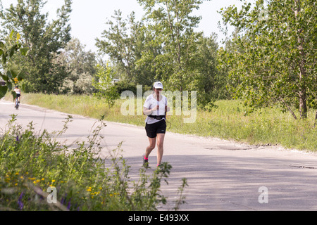 Femme plus âgée jogging dans la rue Leslie Spit ou Tommy Tompson Park à Toronto (Ontario) Banque D'Images