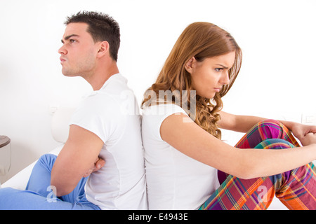 Triste en colère et couple having an argument alors qu'ils assis sur le lit, chambre intérieure atmosphère Banque D'Images