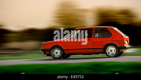 VW Golf GTI rouge tournant sur la route Banque D'Images