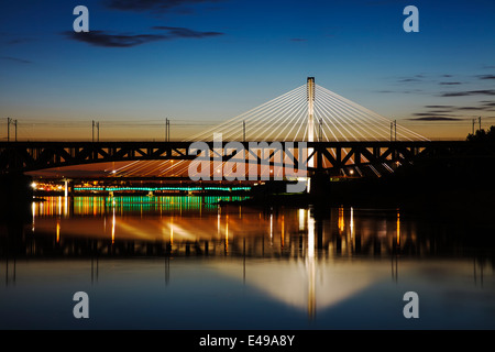 Bridge at night rétroéclairé et reflétée dans l'eau. Swietokrzystki pont. Banque D'Images