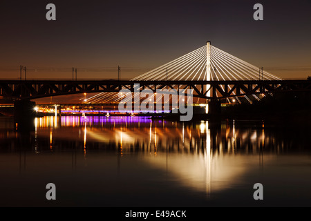 Bridge at night rétroéclairé et reflétée dans l'eau. Swietokrzystki pont. Banque D'Images