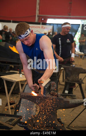 Calgary, Alberta, Canada. 06 juillet 2014. Le farrier prépare des chaussures de cheval chaudes sur enclume tout en participant au dernier tour de la compétition des Blacksmitths aux Championnats du monde au Stampede de Calgary le dimanche 6 juillet 2014. Les cinq premiers ferriers sont en compétition pour le titre de champion du monde dans cette tradition de longue date au Stampede. Calgary, Alberta, Canada. Crédit: Rosanne Tackaberry/Alay Live News Banque D'Images