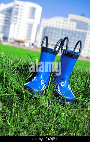 Bottes en caoutchouc enfant bleu foncé sur une herbe Banque D'Images