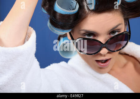 Femme portant des lunettes de soleil et hair rollers Banque D'Images