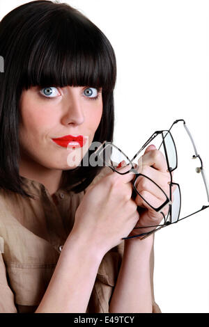 Jolie femme avec de nombreuses paires de lunettes Banque D'Images