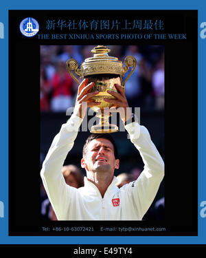 SPORTS XINHUA PHOTO DE LA SEMAINE (du 30 juin au 7 juillet 2014) transmis le 7 juillet 2014 de la Serbie de Novak Djokovic détient le trophée après avoir remporté la finale du tournoi contre la suisse Roger Federer au tournoi de Wimbledon Wimbledon en 2014, le sud-est de Londres, le 6 juillet 2014. Djokovic a gagné 3-2. (Xinhua/Meng Yongmin) Banque D'Images