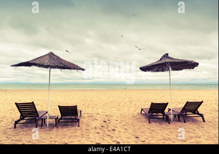 Des chaises longues et des parasols sur la plage de sable vide. Photo couleur Banque D'Images