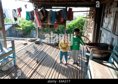 Les jeunes frères tribaux Apatani sur la terrasse en bambou de leur maison traditionnelle en après-midi, Ziro, de l'Arunachal Pradesh, Inde Banque D'Images