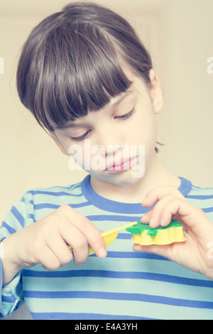 Portrait de petite fille avec la faucheuse et argile verte Banque D'Images