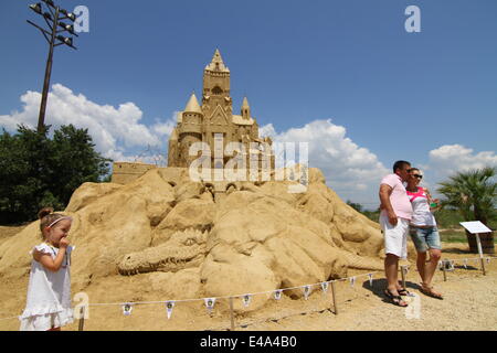 Burgas, le BGR. 7 juillet, 2014. Les visiteurs marchent passé sculptures de sable au cours de l'international festival de sculptures de sable dans la ville bulgare de Burgas est de la capitale Sofia, juillet, 5, 2014. La ville organise le festival pour la septième fois. Plus de 50 artistes du Canada, des États-Unis, de la Russie, le Royaume-Uni, le Japon, la Belgique, la Norvège et d'autres pays prennent part au festival. Photo par : Petar Petrov /Impact Presse Groupe/ Crédit : Petar Petrov/NurPhoto/ZUMA/Alamy Fil Live News Banque D'Images