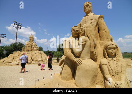 Burgas, le BGR. 7 juillet, 2014. Les visiteurs marchent passé sculptures de sable au cours de l'international festival de sculptures de sable dans la ville bulgare de Burgas est de la capitale Sofia, juillet, 5, 2014. La ville organise le festival pour la septième fois. Plus de 50 artistes du Canada, des États-Unis, de la Russie, le Royaume-Uni, le Japon, la Belgique, la Norvège et d'autres pays prennent part au festival. Photo par : Petar Petrov /Impact Presse Groupe/ Crédit : Petar Petrov/NurPhoto/ZUMA/Alamy Fil Live News Banque D'Images