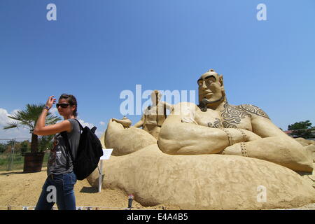 Burgas, le BGR. 7 juillet, 2014. Les visiteurs marchent passé sculptures de sable au cours de l'international festival de sculptures de sable dans la ville bulgare de Burgas est de la capitale Sofia, juillet, 5, 2014. La ville organise le festival pour la septième fois. Plus de 50 artistes du Canada, des États-Unis, de la Russie, le Royaume-Uni, le Japon, la Belgique, la Norvège et d'autres pays prennent part au festival. Photo par : Petar Petrov /Impact Presse Groupe/ Crédit : Petar Petrov/NurPhoto/ZUMA/Alamy Fil Live News Banque D'Images