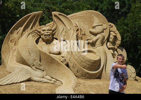 Burgas, le BGR. 7 juillet, 2014. Les visiteurs marchent passé sculptures de sable au cours de l'international festival de sculptures de sable dans la ville bulgare de Burgas est de la capitale Sofia, juillet, 5, 2014. La ville organise le festival pour la septième fois. Plus de 50 artistes du Canada, des États-Unis, de la Russie, le Royaume-Uni, le Japon, la Belgique, la Norvège et d'autres pays prennent part au festival. Photo par : Petar Petrov /Impact Presse Groupe/ Crédit : Petar Petrov/NurPhoto/ZUMA/Alamy Fil Live News Banque D'Images