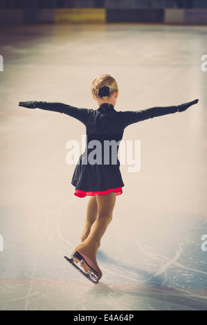 Jeune femme, patineuse artistique déménagement sur patinoire à la concurrence Banque D'Images