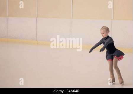 Jeune femme, patineuse artistique déménagement sur patinoire Banque D'Images