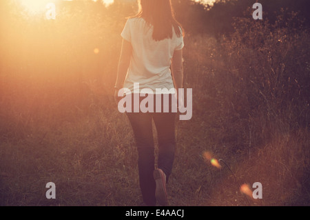 Mid adult woman walking in field Banque D'Images