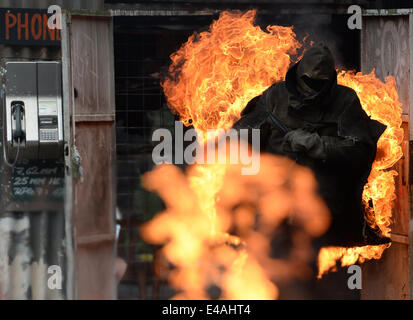 Un cascadeur en feu traverse la soi-disant Vulkan Arena pendant un formidable spectacle à studios Babelsberg à Potsdam, Allemagne, 7 juillet 2014. Le Stunt arena a été construite il y a 15 ans et a montré jusqu'à 3 333 montre avec plus de 5 millions de visiteurs depuis. Photo : Ralf Hirschberger/dpa Banque D'Images