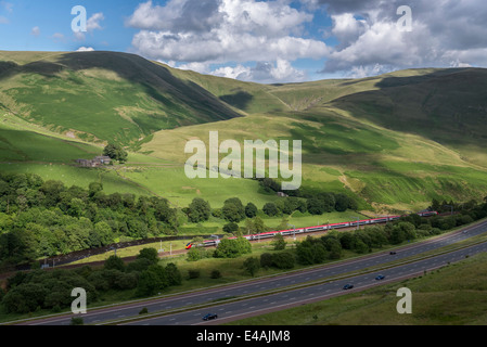 Le M6 fonctionne grâce à la Lune en Cumbria Gorge nord-ouest de l'Angleterre. Un Pendolino Virgin se dirige vers le sud sur la West Coast Main Line. Banque D'Images