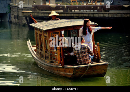 CHENGDU, Chine : les touristes profiter d'un trajet sur un bateau en bois qu'elle glisse le long d'un canal à l'eau Ville Long Tan Banque D'Images