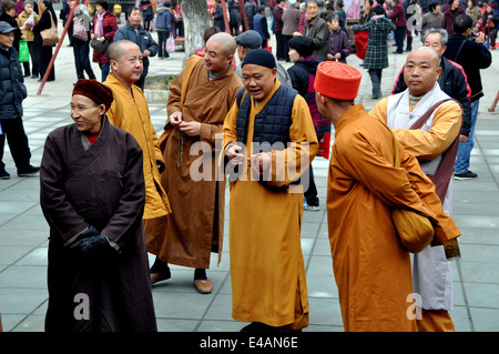 PENGZHOU, Chine : un groupe de moines portant orange, marron et beige, peignoirs dans la cour du monastère de Xing Long Banque D'Images