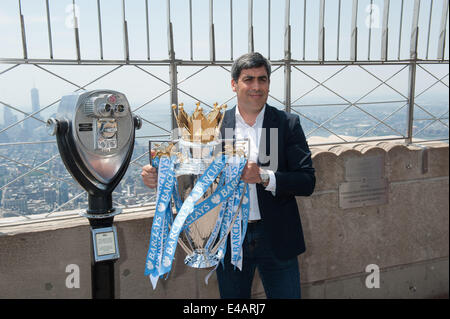 Manhattan, New York, USA. 7 juillet, 2014. L'ex-joueur de l'équipe nationale masculine et Manchester City player Claudio Reyna hisse le 2014 Barclay's Premiere League Trophy, remporté par Manchester City, sur l'Empire State Building, l'Observatoire du 86e étage du lundi 7 juillet 2014. Credit : Bryan Smith/ZUMA/Alamy Fil Live News Banque D'Images
