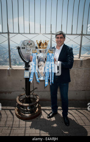 Manhattan, New York, USA. 7 juillet, 2014. L'ex-joueur de l'équipe nationale masculine et Manchester City player Claudio Reyna hisse le 2014 Barclay's Premiere League Trophy, remporté par Manchester City, sur l'Empire State Building, l'Observatoire du 86e étage du lundi 7 juillet 2014. Credit : Bryan Smith/ZUMA/Alamy Fil Live News Banque D'Images