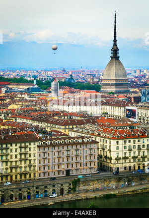 Vue de la ville de Turin, Italie du Convento Monte dei Cappuccini. Le Po à l'avant-plan. Sur la gauche un ballon à air chaud s'élève dans le ciel. À droite, la flèche de la Mole Antonelliana. Les Alpes s'élèvent dans l'arrière-plan. Banque D'Images