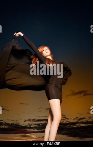 Belle femme avec des cheveux rouge brillant long châle en mousseline danse avec Banque D'Images