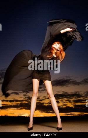 Belle femme avec des cheveux rouge brillant long châle en mousseline danse avec Banque D'Images