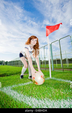 Belle jeune fille rousse joue au soccer Banque D'Images