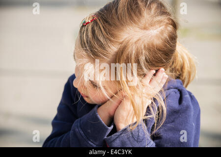 Blonde girl resting head in hands, Munich, Bavière, Allemagne Banque D'Images