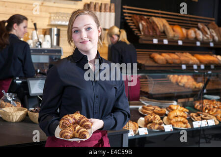 Waitress serving organic croissants au coffee shop Banque D'Images