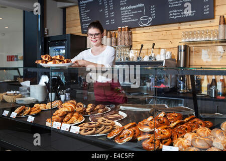 Serveuse dans un café d'organiser les croissants sur la lutte contre Banque D'Images