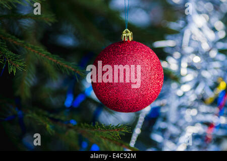 Vue rapprochée d'une décoration rouge boule qui se balance sur l'arbre de Noël Banque D'Images