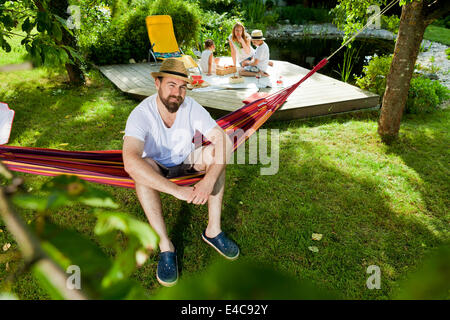 Man relaxing on hammock, en arrière-plan, Munich, Bavière, Allemagne Banque D'Images