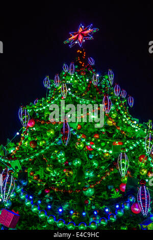 Arbre de Noël artificiel contre le ciel de nuit pluvieuse Banque D'Images