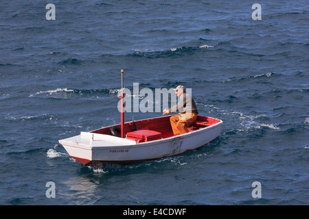 Getaria, Gipuzkoa, Pays Basque, Espagne. Un pêcheur local dans un petit bateau brave la mer difficile. Banque D'Images