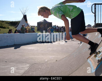 La planche en descendant un half-pipe skatepark à Bude, Cornwall, UK Banque D'Images