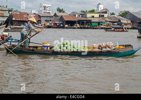 Woman rowing un sampan et vente de fruits et légumes, pouvez Rang marché flottant, Can Tho, Vietnam Banque D'Images