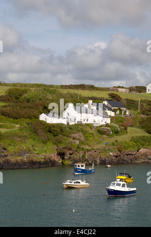 Bateaux ancrés dans le port avec des chalets sur le coteau, Abercastle, Pembrokeshire Banque D'Images