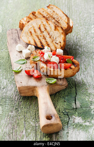 Bruschetta italienne et concassé de tomates, basilic et fromage sur du pain croûté grillé Banque D'Images