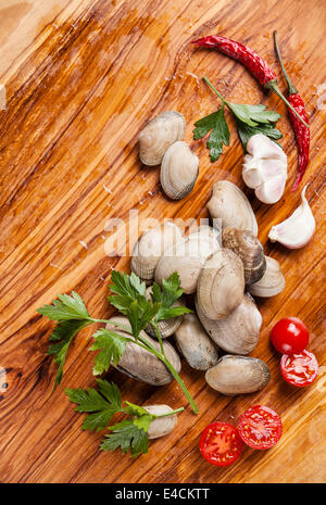 Ingrédients pour la cuisson des coquillages crus vongole vongole, les feuilles de persil, tomates cerises Banque D'Images