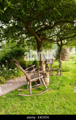 Fauteuil à bascule en bois et swing en jardin de chalet Banque D'Images