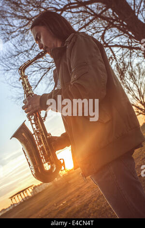 Homme jouant du saxophone au coucher du soleil, Osijek, Croatie Banque D'Images