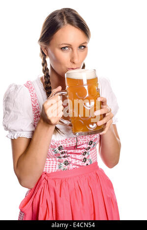 Belle jeune femme avec ses cheveux en tresses portant un dirndl boire de la bière à partir d'un très grand verre tankard avec un regard d'ant Banque D'Images