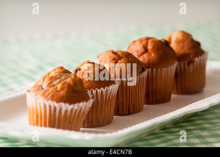 Une rangée de mini-muffins affichée sur un plaque rectangulaire blanche Banque D'Images